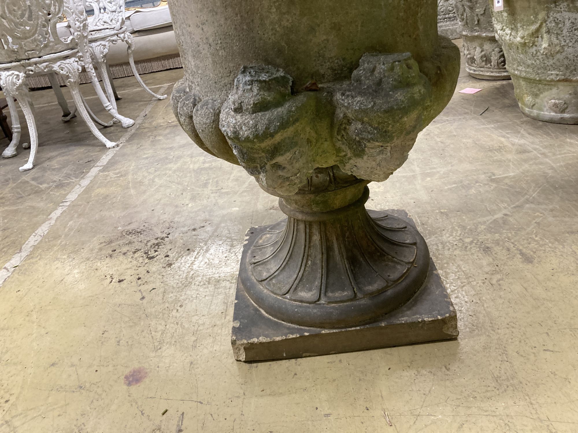 A large reconstituted stone campana garden urn, handles in need of repair, 75cm diameter, height 96cm